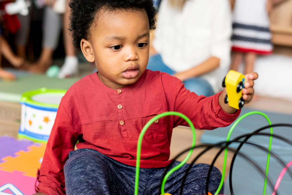 Little boy playing with toys in the playroom.