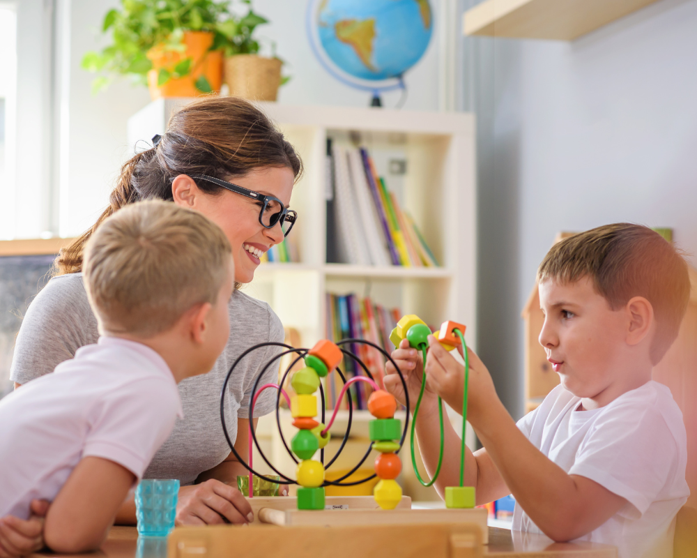 Preschool teacher with children playing with didactic toys 