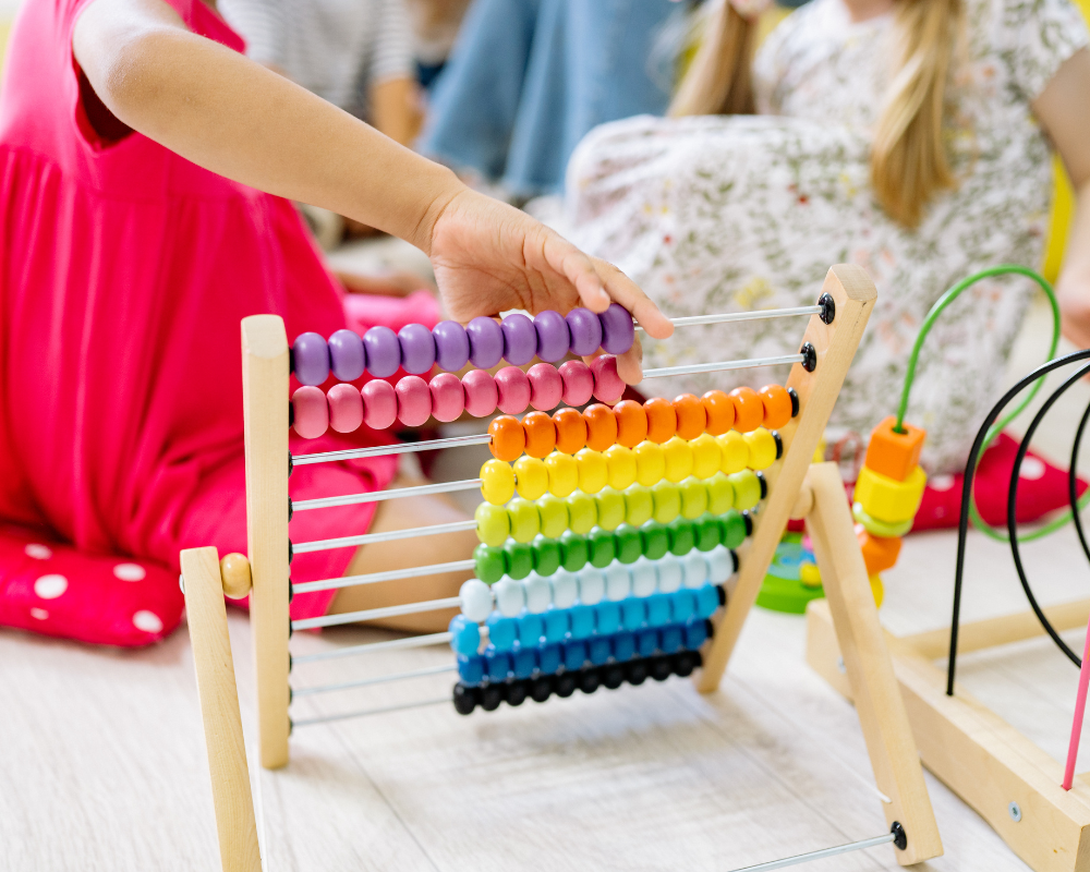 Child holding bright multi-coloured wooden abacus 