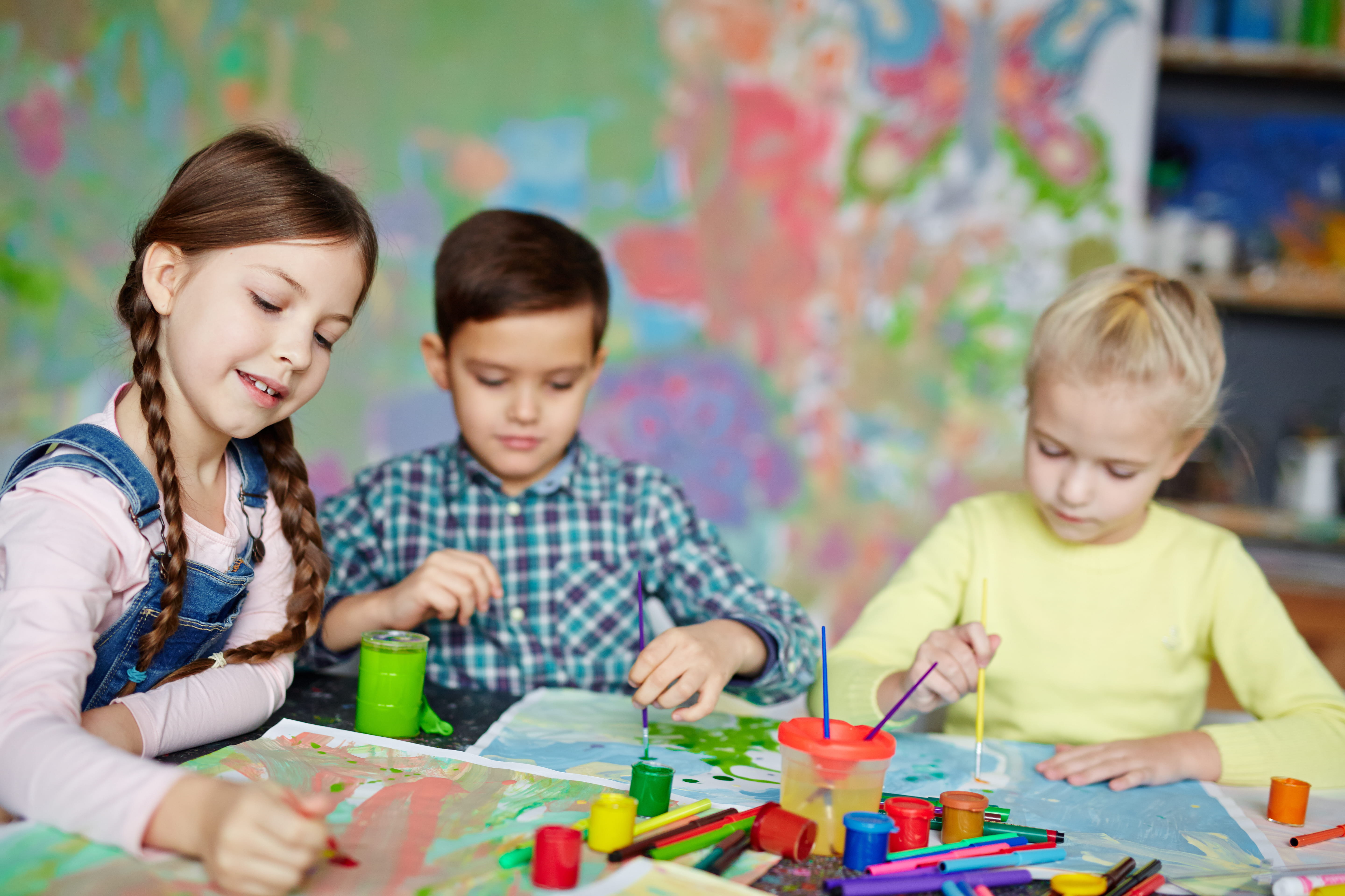 Group of kids painting at table together