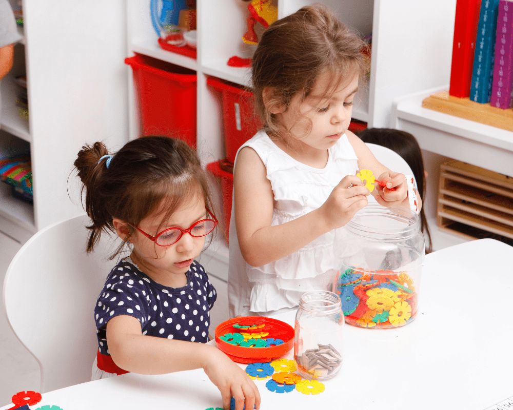 Two preschool children playing with colourful toy blocks