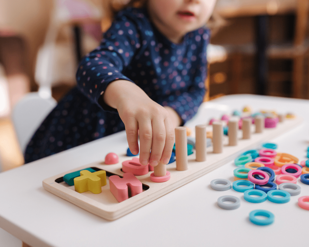 Child playing with an educational and interactive game with different coloured numbers and letters